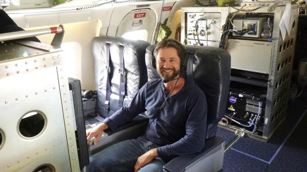 Karl Froyd, a former CIRES scientist during the Atmospheric Tomography Mission, is strapped in his workstation aboard the NASA DC-8 during one of the flights. Measurements made by the PALMS instrument allowed the research team to document that desert dust is a major contributor to the formation of icy cirrus clouds. Credit: Dan Murphy, NOAA