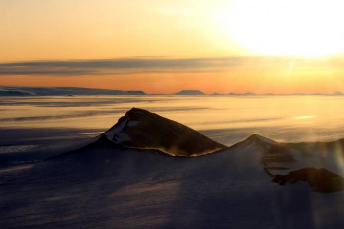 The Shackleton Range in Antarctica at sunset with snow blowing off the ridges, photographed during an Operation IceBridge flight on Oct. 10, 2018. Credits: NASA/Michael Studinger