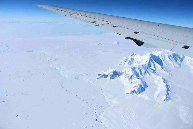 The mountains of northern Alexander Island in the Antarctic Peninsula, passing under the left wing of the DC-8 aircraft carrying Operation IceBridge¹s scientists and instruments on Oct. 14, 2016. Credits: NASA/John Sonntag