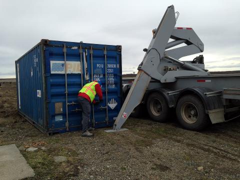 D. Chirica assists with the placement of sea container.